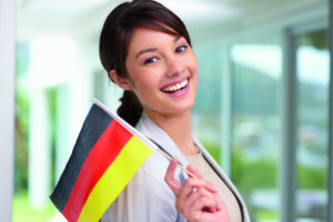 Beautiful young woman smiling with a German flag